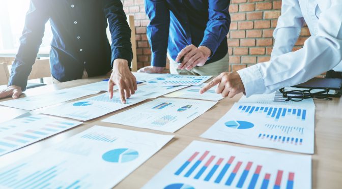 A group of business people discuss OB3 investment and property provisions.